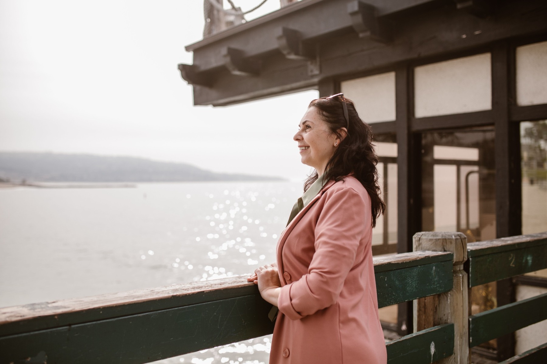 A woman smiling as she looks across the water